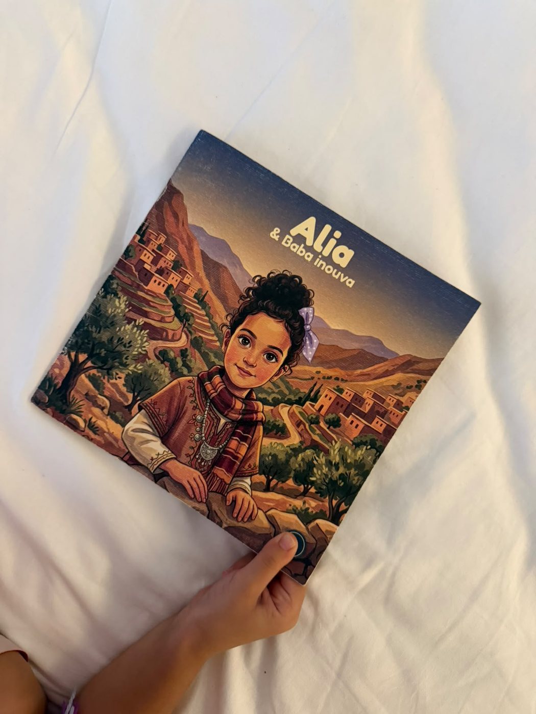 Livre imprimé tenu en main, format carré