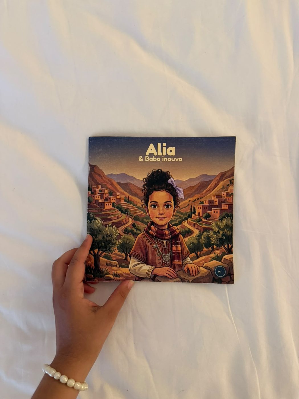 Livre imprimé tenu en main, format carré